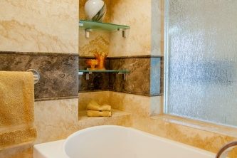 Master bathroom addition in Phoenix, Arizona -  featuring Forza Stone panels, an accessible shower and a walk-in jetted tub.