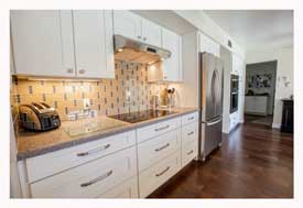 Phoenix AZ Open Concept galley kitchen with white cabinets and gray quartz countertops. 