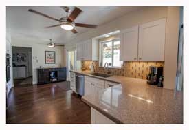 Phoenix AZ Open Concept galley kitchen with white cabinets and gray quartz countertops. 