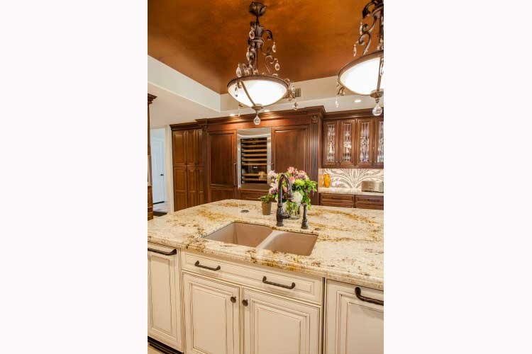 Paradise Valley Kitchen remodeling Contractor-Luxurious kitchen renovation with a large island, two toned wood cabinets, a stone cook-top hood and LED lighting.