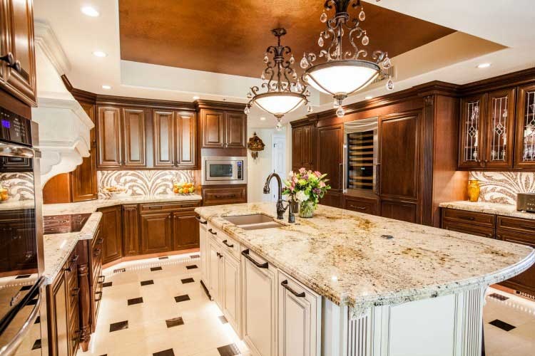 Award winning Scottsdale Kitchen Transformation. Upscale Scottsdale kitchen remodel with rich custom cabinets, a large center island, a stone cook-top hood and LED lighting.