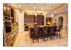 Open Concept kitchen with dark wood cabinets granite counters and island seating in Phoenix AZ.