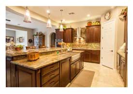 Open Concept kitchen with dark wood cabinets granite counters and island seating in Phoenix AZ.