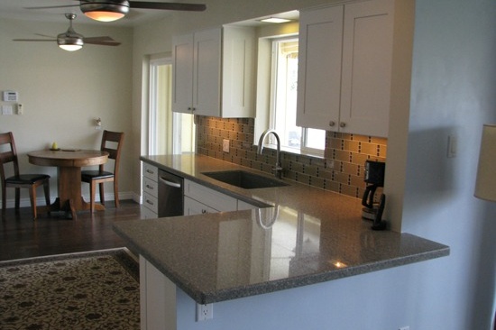 Kitchen Remodeling Contractor in Phoenix, AZ. Open concept galley kitchen renovation with gray quartz counter tops and white cabinets.