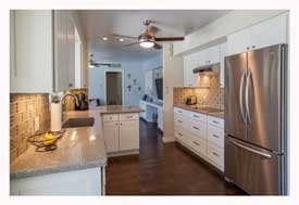 Phoenix AZ Open Concept galley kitchen with white cabinets and gray quartz countertops. 